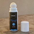 White 3 fl oz roll-on bottle with a rounded cap and black label featuring "GRAIL™ Botanical Roll-On" and "Cooling Menthol" text, placed on a neutral stone surface