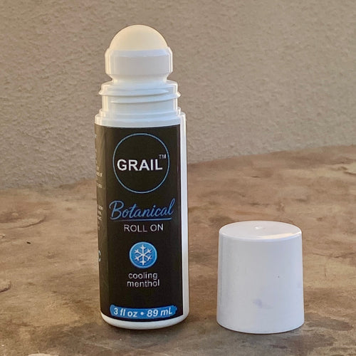 White 3 fl oz roll-on bottle with a rounded cap and black label featuring "GRAIL™ Botanical Roll-On" and "Cooling Menthol" text, placed on a neutral stone surface